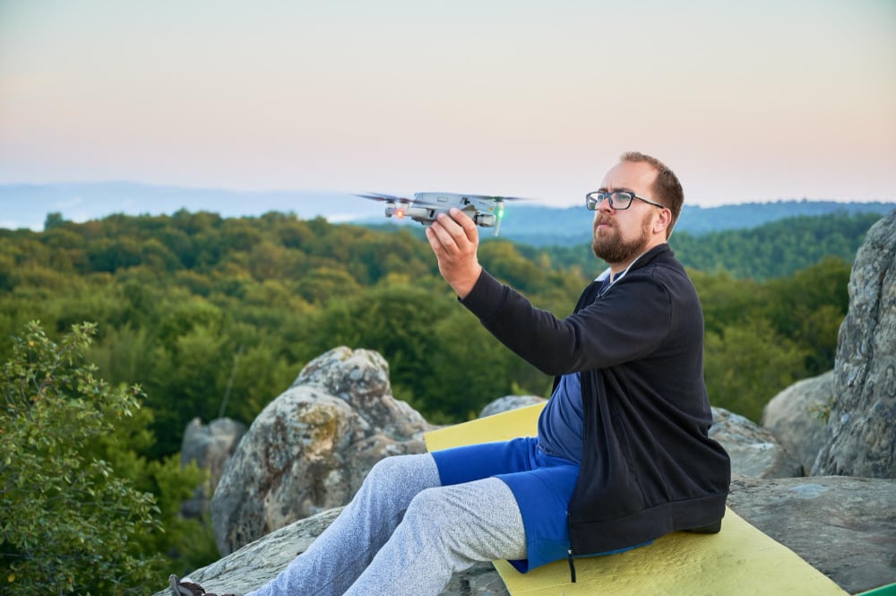 Pilot launching a survey drone above open country